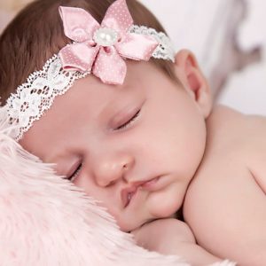Delicate dusky pink satin flower on an ivory lace headband