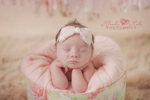 Pink satin bow wrapped in lace with pearl on a soft elastic headband