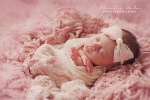 Pink satin bow wrapped in lace with pearl on a soft elastic headband