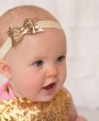 Gold glittery bow decorated with Swarovski crystal on a soft headband