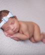 Blue glittery bow decorated with rhinestone on a soft headband
