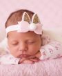 Pink bunny ears with glitter and pom pom on a soft elastic headband